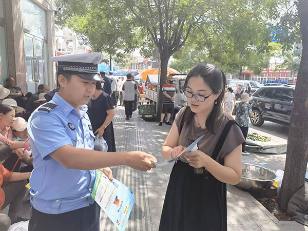 新民交警走进集市开展交通安全宣传活动.jpg